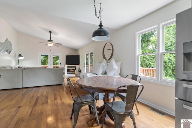 dining area with ceiling fan, light hardwood / wood-style flooring, a healthy amount of sunlight, and lofted ceiling