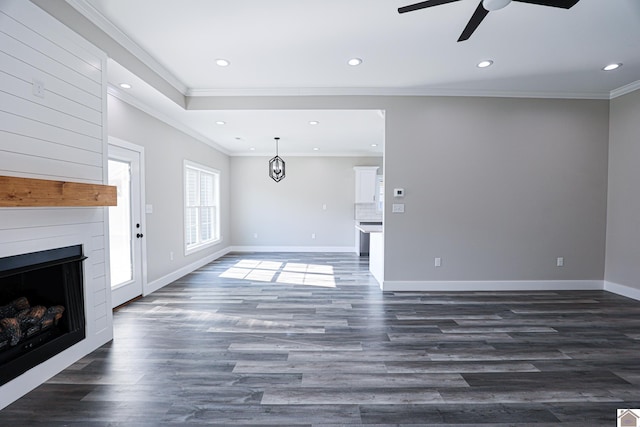 unfurnished living room featuring ceiling fan, dark wood-type flooring, and ornamental molding