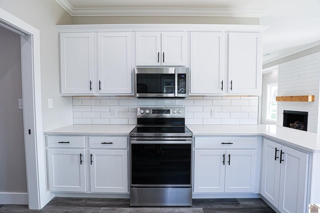 kitchen featuring dark wood-style floors, light countertops, ornamental molding, and stainless steel appliances
