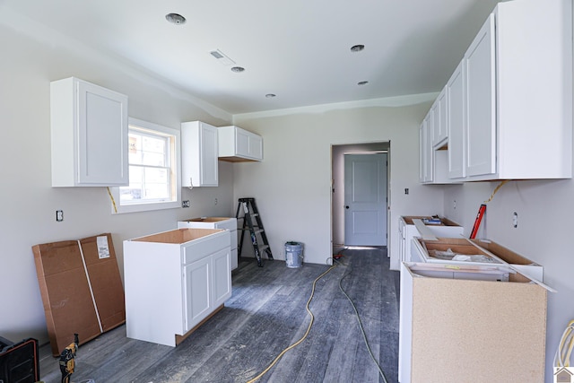 kitchen featuring dark hardwood / wood-style flooring and white cabinetry