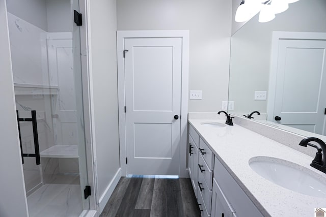 bathroom with double vanity, wood finished floors, and a sink