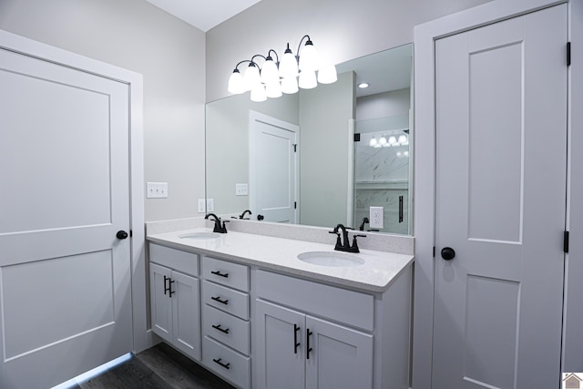 full bathroom with double vanity, wood finished floors, and a sink