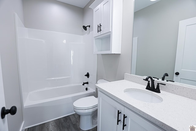 full bathroom featuring toilet, vanity,  shower combination, and wood finished floors