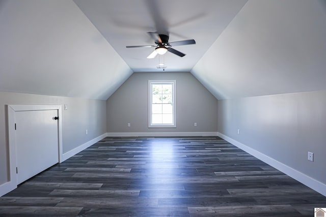 additional living space with vaulted ceiling, dark wood-style flooring, baseboards, and a ceiling fan