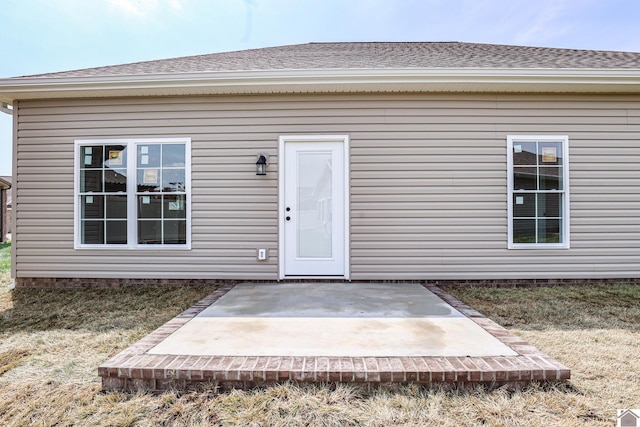 view of exterior entry featuring a patio area and a yard