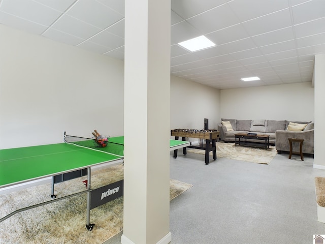 rec room with a paneled ceiling and carpet