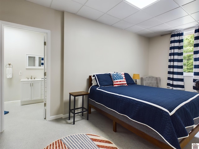 carpeted bedroom featuring sink, connected bathroom, and a paneled ceiling