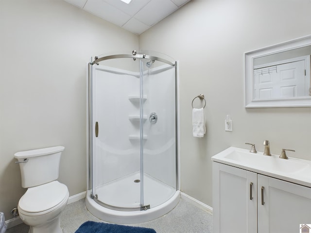 bathroom featuring a shower with door, vanity, and toilet