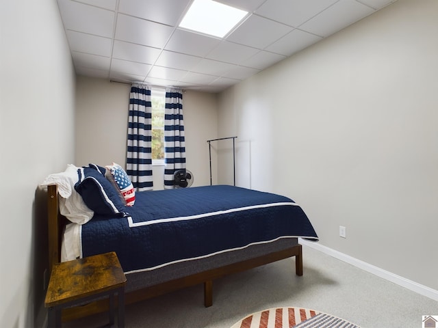 bedroom with carpet flooring and a drop ceiling