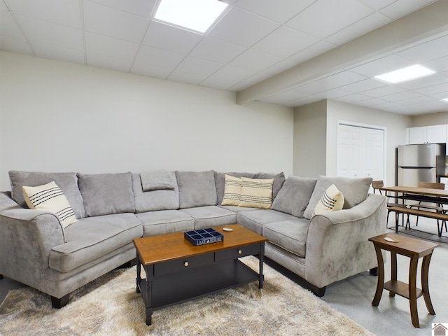 living room with carpet floors and a paneled ceiling