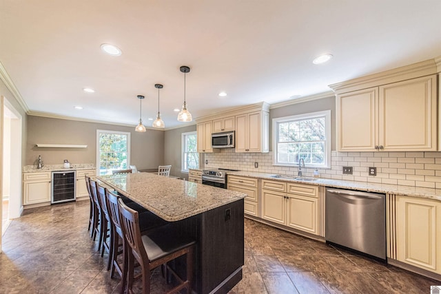 kitchen with light stone countertops, a kitchen breakfast bar, stainless steel appliances, beverage cooler, and pendant lighting