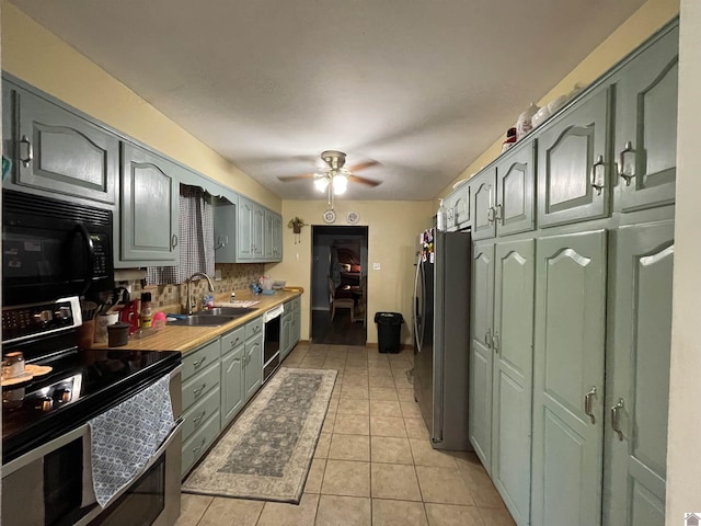 kitchen featuring black appliances, sink, ceiling fan, decorative backsplash, and light tile patterned floors