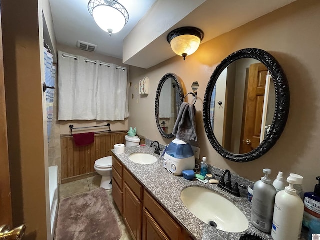 bathroom with tile patterned floors, vanity, toilet, and a bath