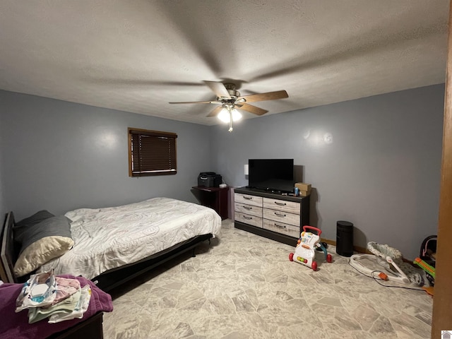 bedroom with ceiling fan and a textured ceiling