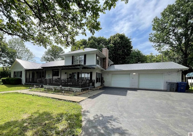 view of front of house featuring covered porch, a garage, and a front yard