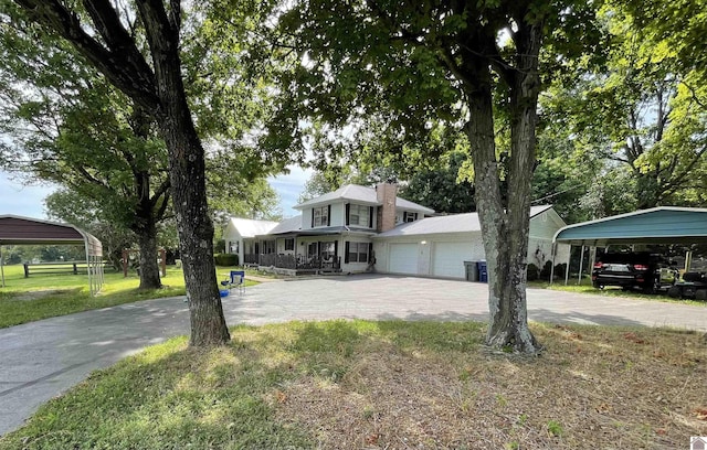 view of front of home with a front lawn, covered porch, and a carport