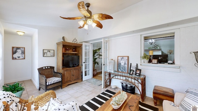 tiled living room with ceiling fan and brick wall