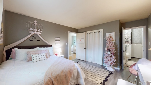 bedroom featuring connected bathroom, light hardwood / wood-style flooring, and a notable chandelier