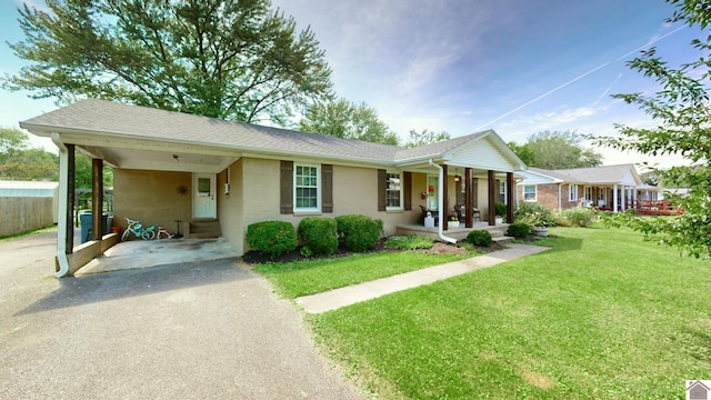 ranch-style house with covered porch and a front lawn