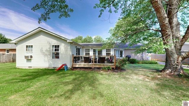 rear view of house with a wooden deck, cooling unit, and a lawn