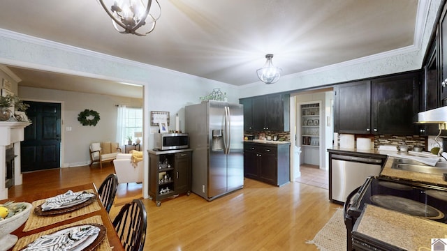 kitchen featuring decorative light fixtures, sink, appliances with stainless steel finishes, and an inviting chandelier