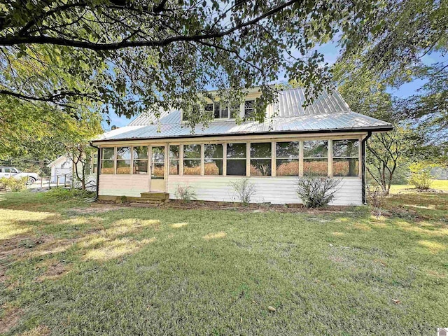 view of front of house with a sunroom and a front yard