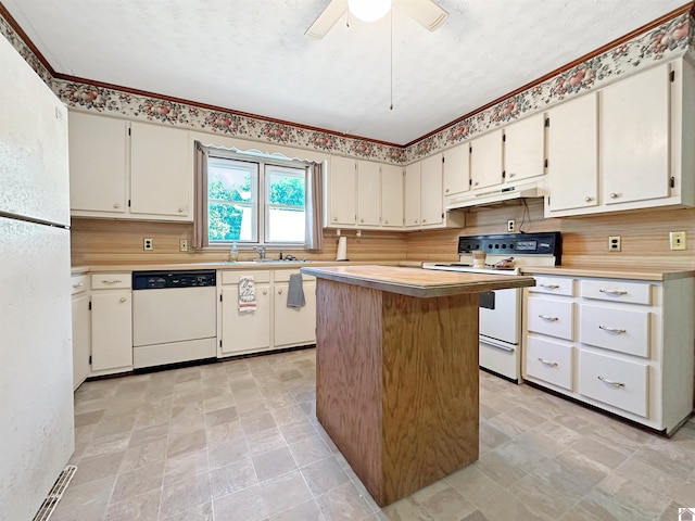 kitchen with ceiling fan, sink, a kitchen island, white appliances, and white cabinets