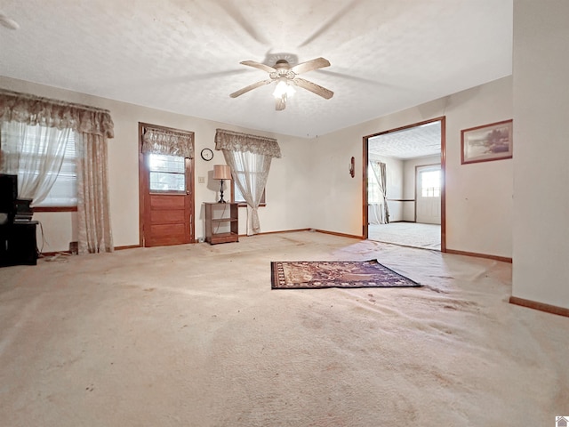 interior space with light carpet, a textured ceiling, and ceiling fan