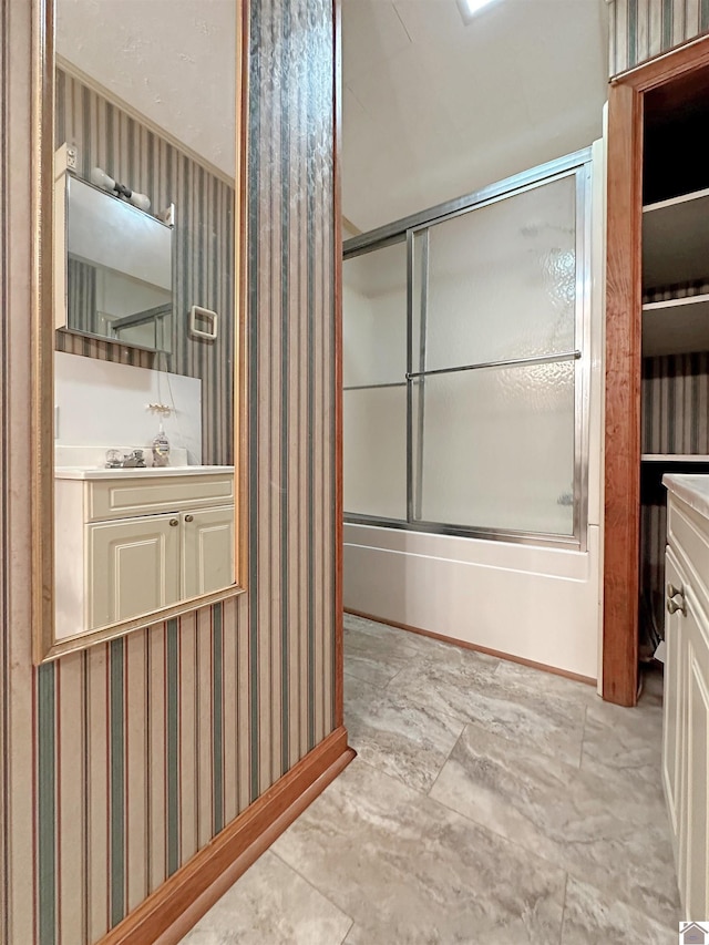 bathroom with vanity and combined bath / shower with glass door