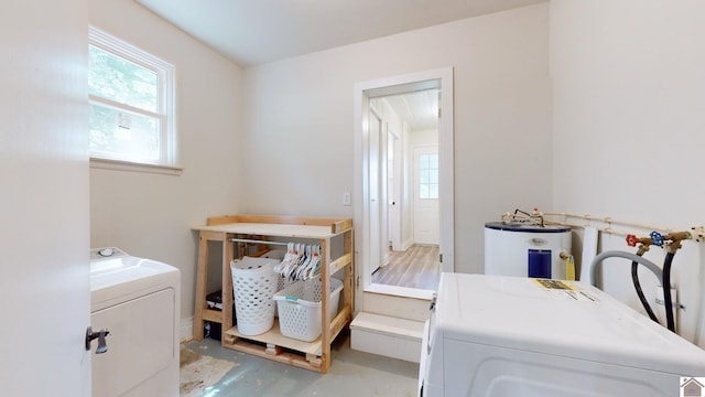 laundry room featuring water heater and independent washer and dryer