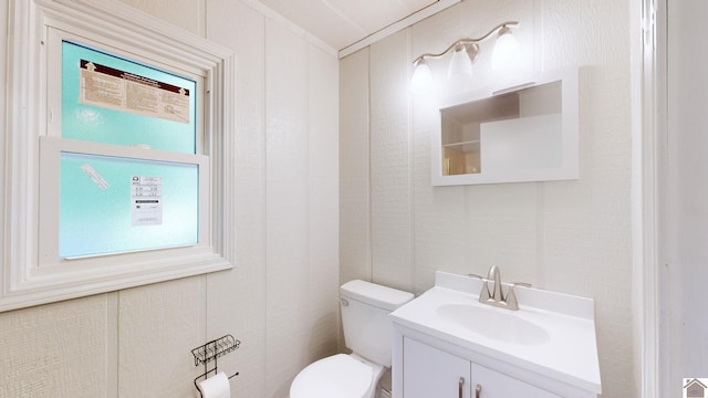 bathroom featuring vanity, toilet, plenty of natural light, and crown molding