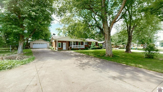 ranch-style home featuring an outdoor structure, covered porch, a front yard, and a garage