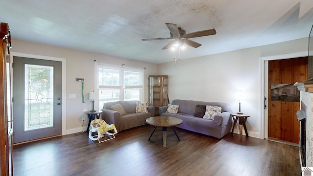 living room featuring dark hardwood / wood-style floors, ceiling fan, and a fireplace