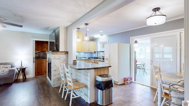 kitchen featuring kitchen peninsula, ceiling fan, white refrigerator with ice dispenser, pendant lighting, and a fireplace