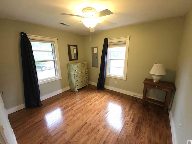 unfurnished bedroom featuring ceiling fan, electric panel, and light hardwood / wood-style flooring