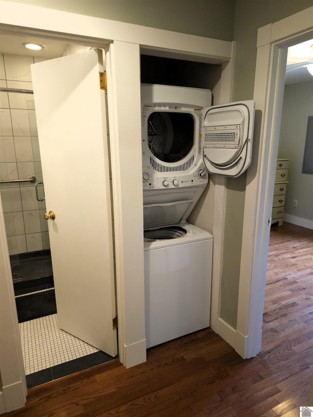 clothes washing area featuring stacked washer and dryer and dark hardwood / wood-style floors