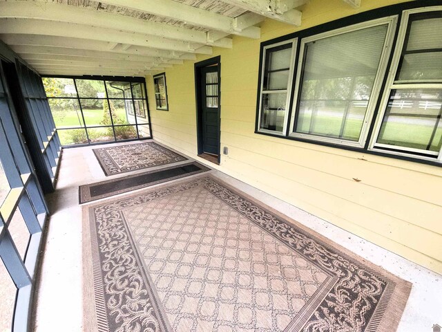 unfurnished sunroom with beamed ceiling