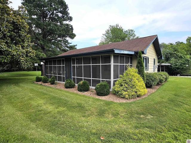 view of side of home with a yard and a sunroom