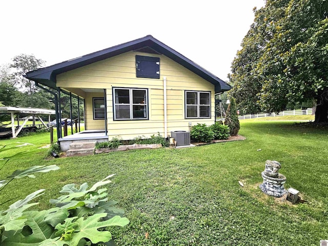 back of house with a lawn, cooling unit, and a porch