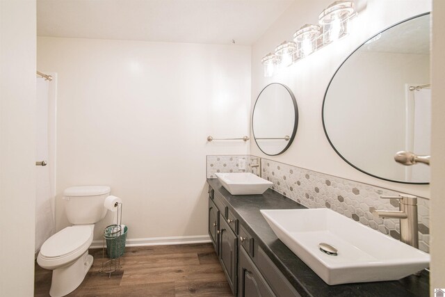bathroom featuring hardwood / wood-style flooring, vanity, toilet, and decorative backsplash