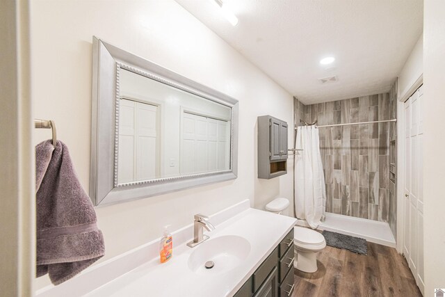 bathroom with vanity, hardwood / wood-style floors, curtained shower, and toilet
