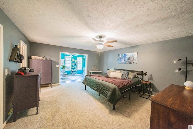 bedroom featuring a textured ceiling, light carpet, access to exterior, and ceiling fan