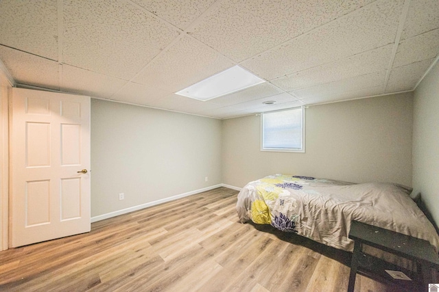 bedroom featuring a paneled ceiling and hardwood / wood-style floors