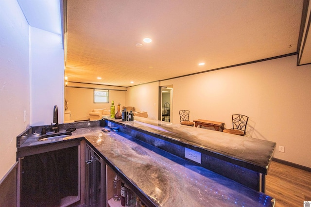 bar with sink, hardwood / wood-style flooring, and ornamental molding