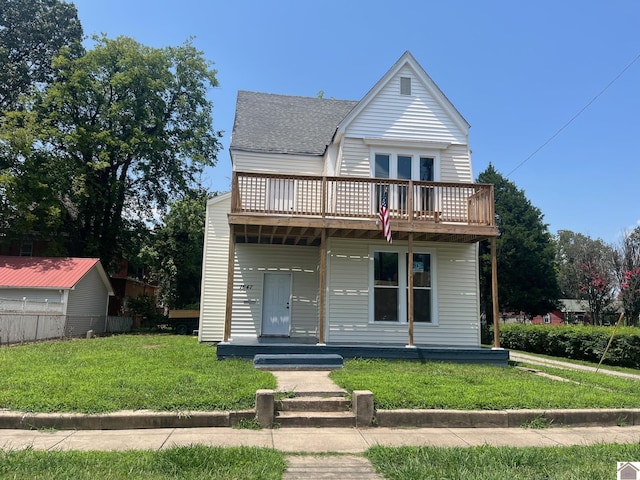 view of front of home featuring covered porch, a balcony, and a front lawn