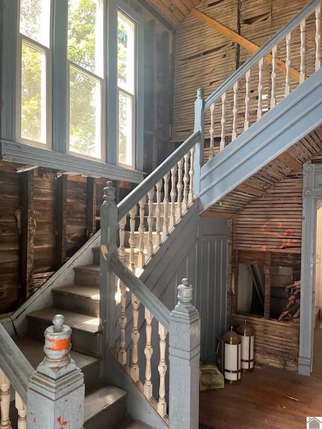 stairs featuring hardwood / wood-style floors and vaulted ceiling