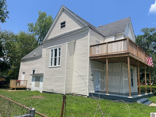 view of side of property featuring a yard and a wooden deck