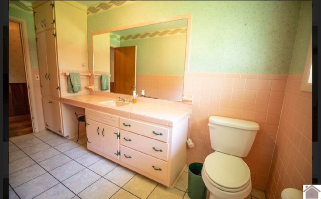 bathroom featuring vanity, toilet, tile walls, and tile patterned flooring