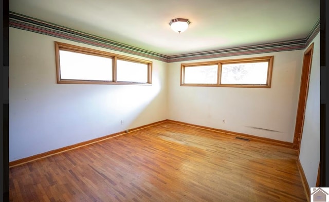 unfurnished room featuring hardwood / wood-style floors and ornamental molding