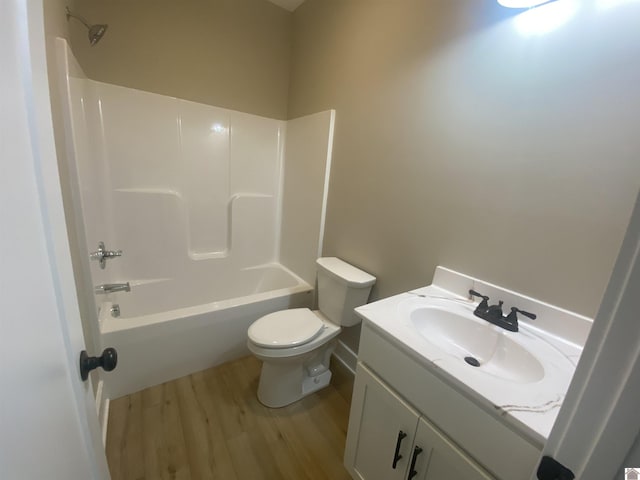 full bath featuring toilet, tub / shower combination, wood finished floors, and vanity